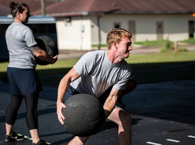 hombre lanzando un balón medicinal